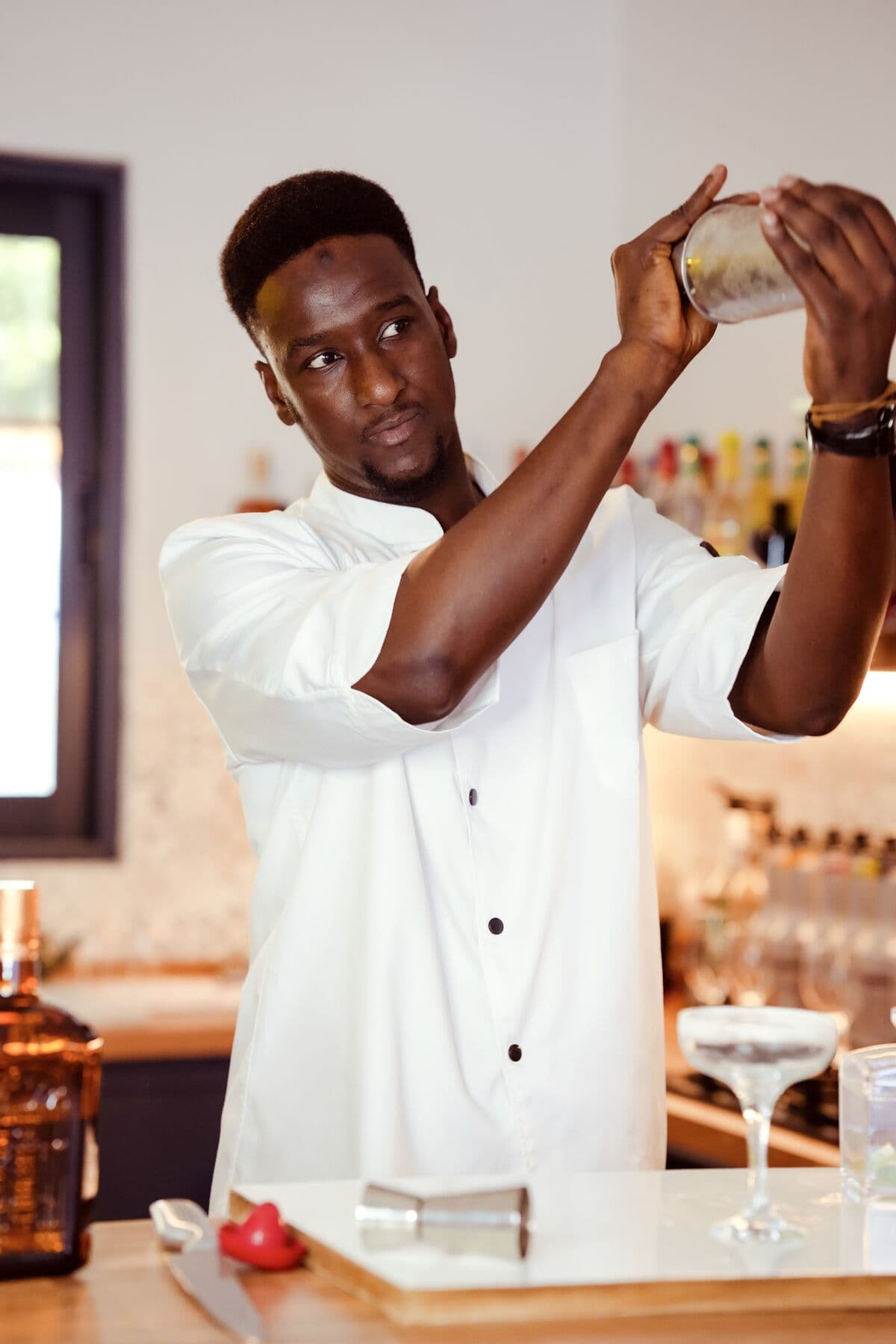 Le barman secoue un shaker derrière le comptoir