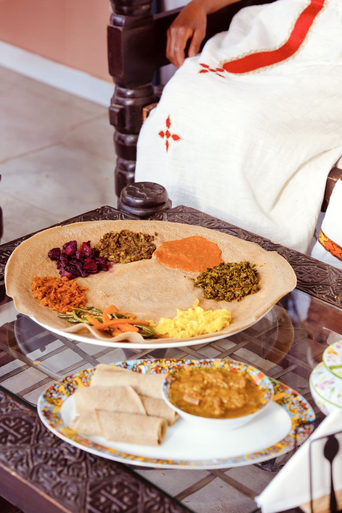 Beyaynetu : lentilles, betterave, légumes et pois cassés disposés sur une grande injera